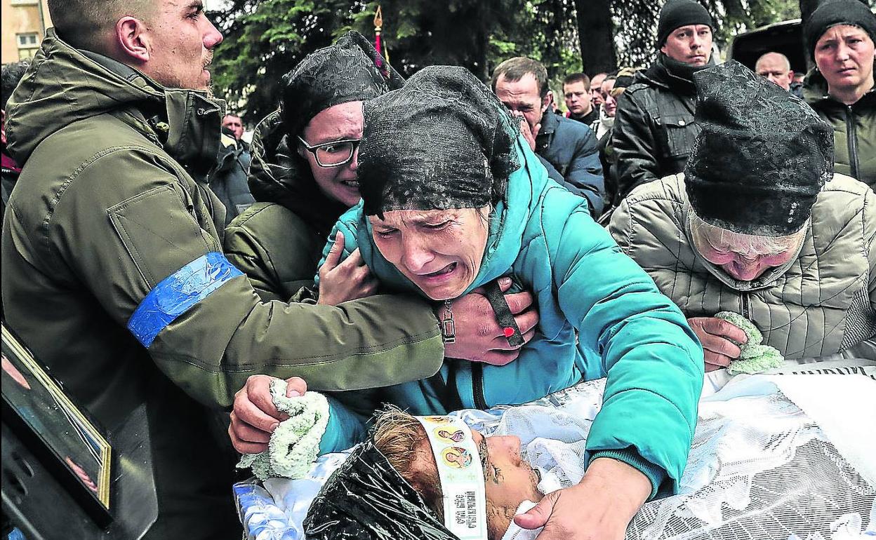 Familiares de un soldado ucraniano fallecido en Mykolaiv se desgarran de dolor durante el funeral, en el Cementerio Occidental de Odesa. 