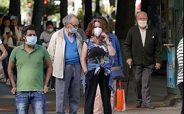 Imagen de archivo de personas por la calle con la mascarilla, donde ya no es obligatoria. 