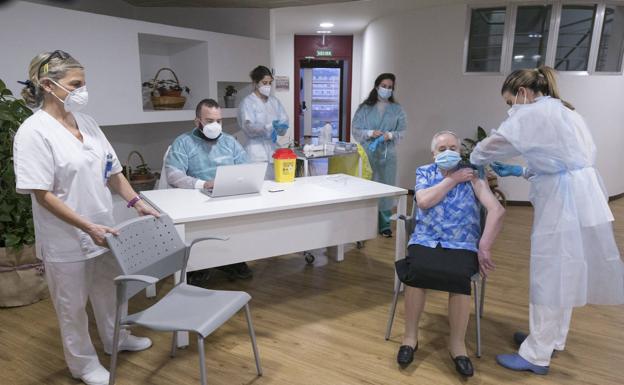 Una residente en un centro de mayores de Asturias recibe la vacuna contra la covid-19.