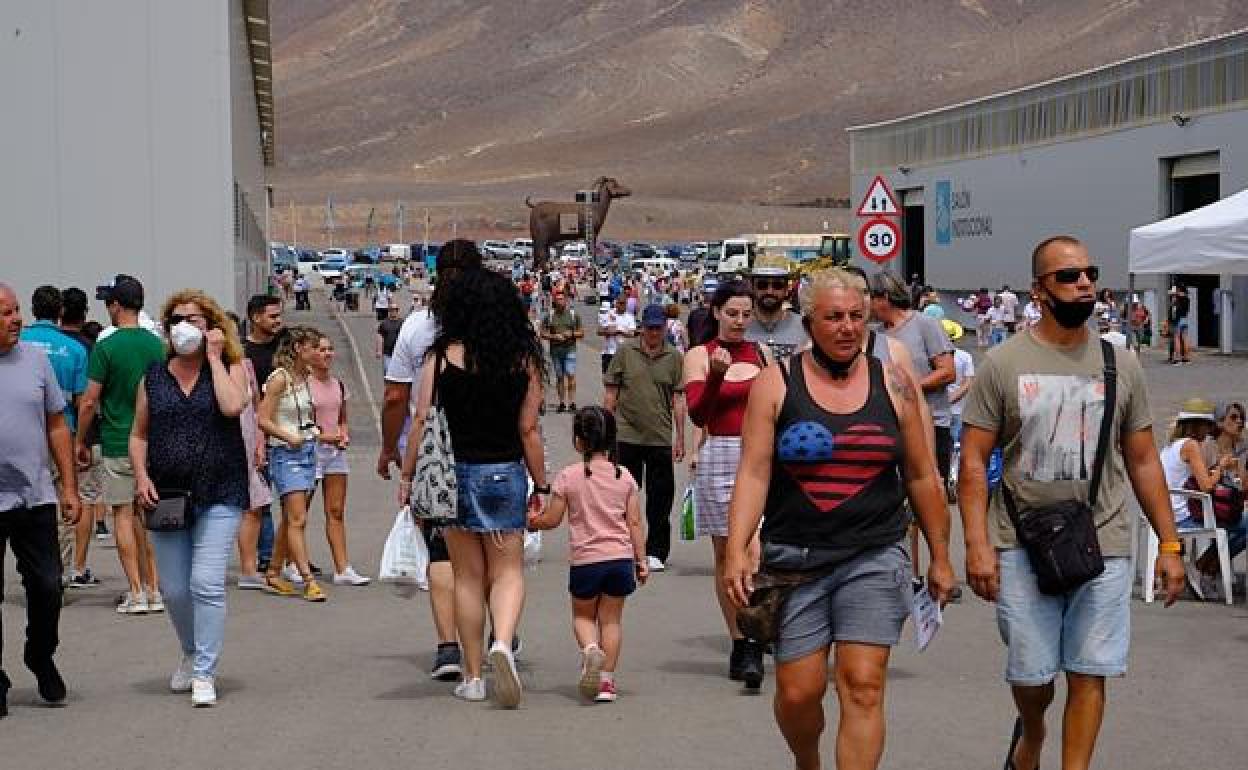 Visitantes de la feria con la escultura de la cabra, de Juan Miguel Cubas, al fondo. 
