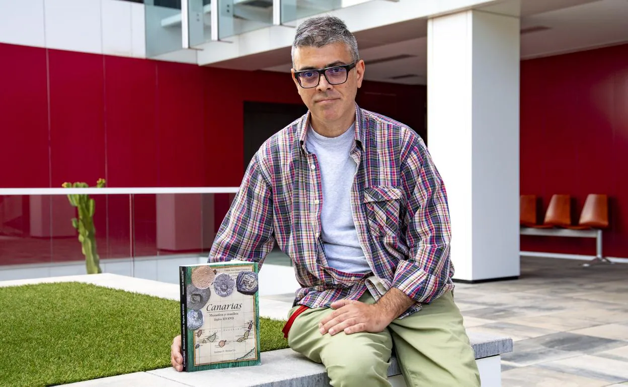 Santiago Medina Gil posa con un ejemplar de 'Canarias. Monedas y resellos. Siglos XIV-XVIII', en la sede de CANARIAS7. 