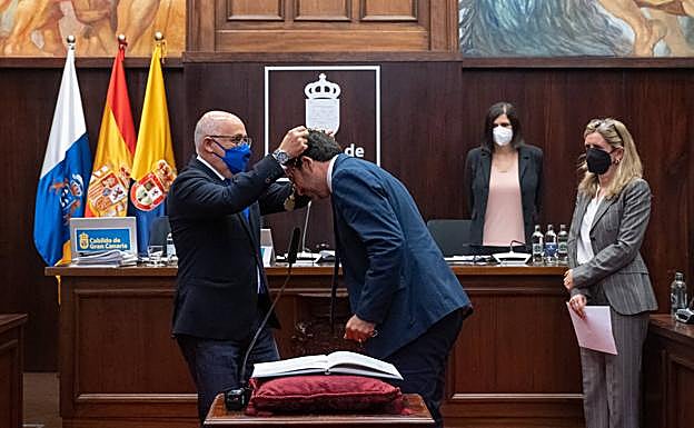 El presidente, Antonio Morales, le coloca la medalla como nuevo consejero del Cabildo. 