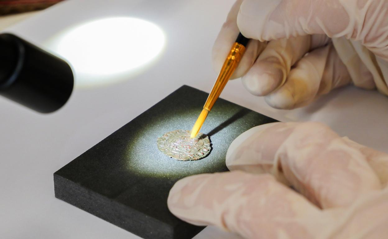 Estudio de una de las monedas de alto valor patrimonial encontrada en el yacimiento sureño. 