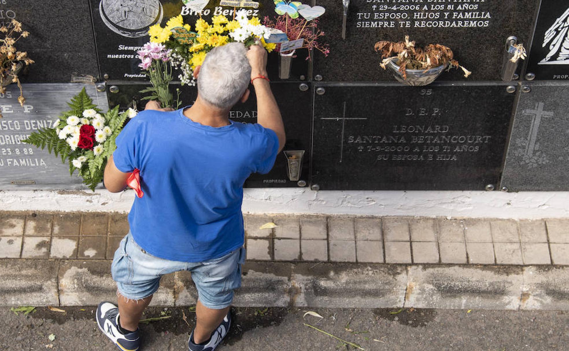 Un ciudadano deposita flores en la tumba de un ser querido. 