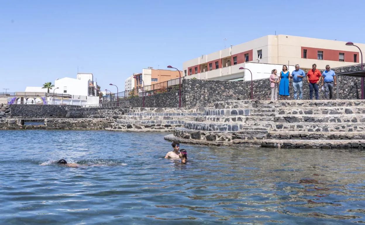 El alcalde Juan Jiménez y varios concejales, en la piscina natural remodelada, con la residencia militar detrás. 