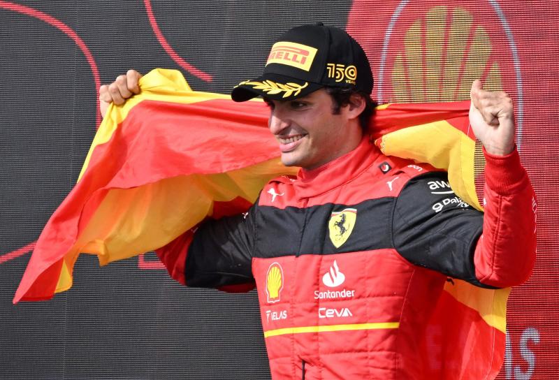 Carlos Sainz posa con la bandera española en lo más alto del podio.