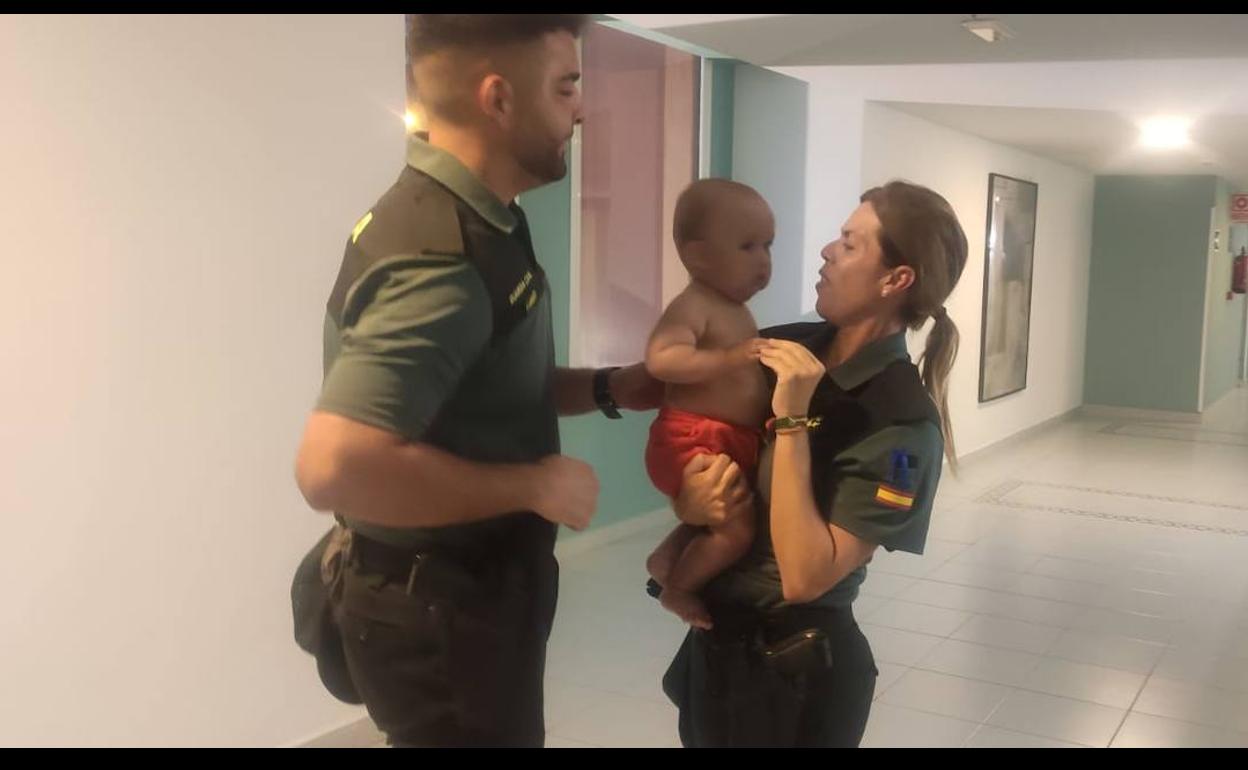 Los dos agentes del puesto principal de Morro Jable (Pájara) con el bebé al que salvaron la vida. 