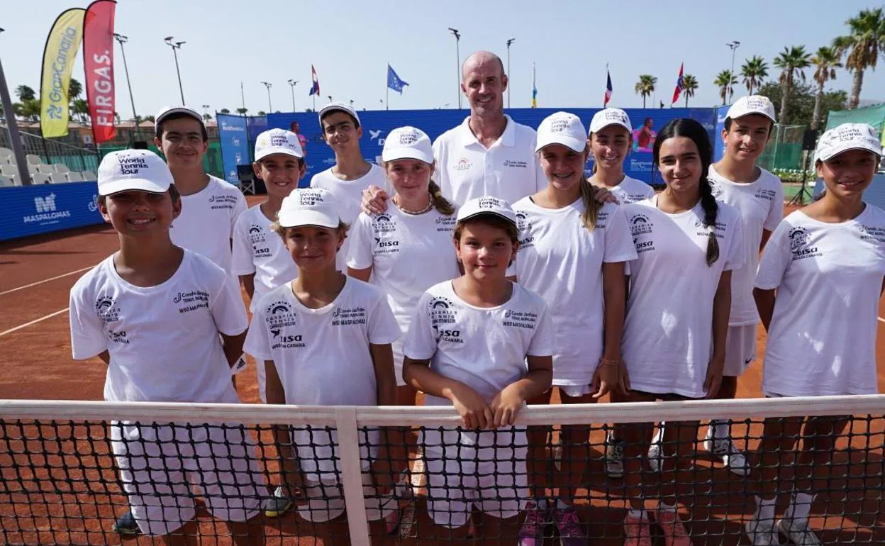Marcos Conde, en una pista de tenis y rodeado de jóvenes aprendices. 