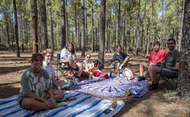 Imagen principal - Arriba: María Moreno, a la izquierda y sus amigos llevaban dos años planeando la escapada. Abajo: Pablo Cruz, a la izquierda, y sus colegas llegaron a los LLanos de la Pez el martes. Abajo, derecha: Antonio Escolar ordena la ropa en su caseta. 