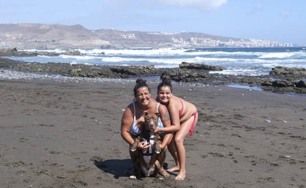 Alcira, su hija y Balú posan en la orilla de Bocabarranco, la única playa de Telde que permite mascotas. 
