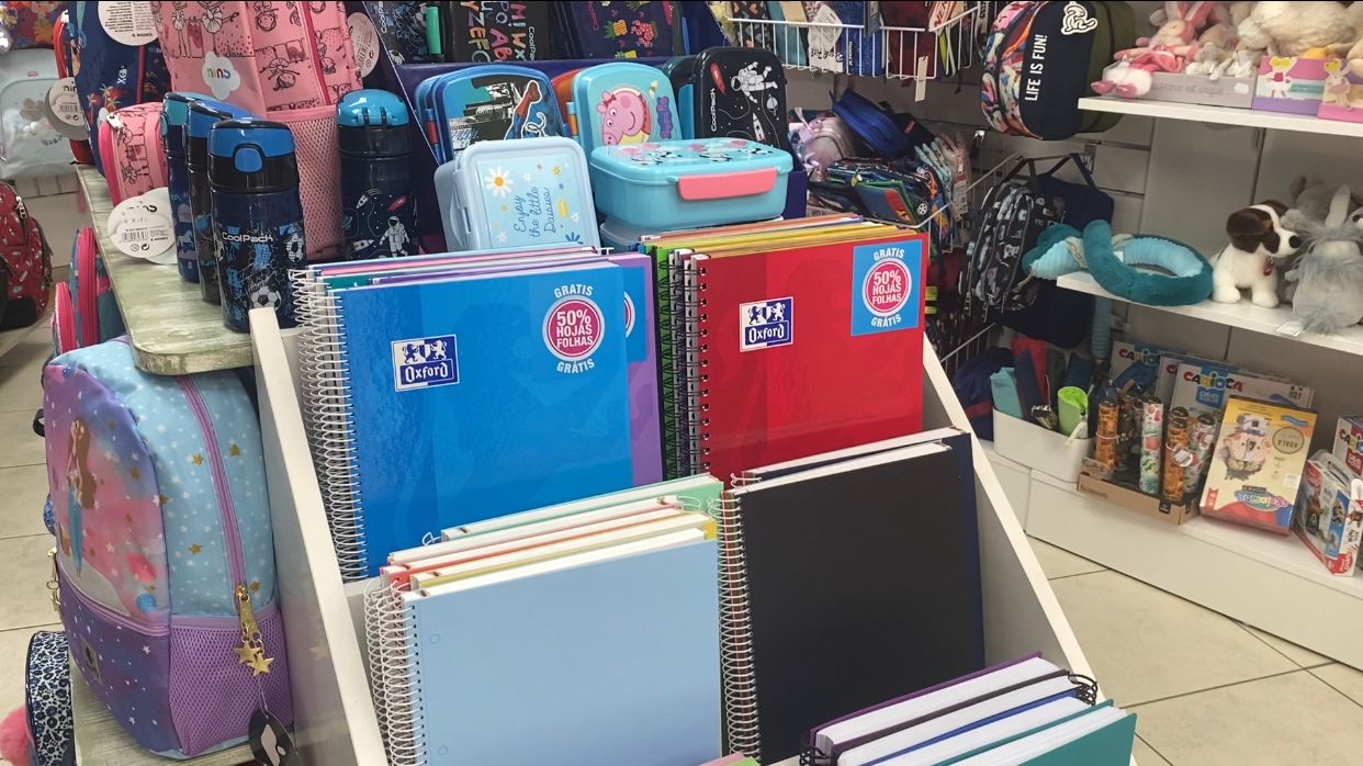 Imagen secundaria 1 - Arriba, familias haciendo cola para recoger los libros del nuevo curso en la librería. Abajo, a la izquierda, material escolar para este curso. Abajo, a la derecha, Carolina Sánchez, responsable en El Libro Técnico. 