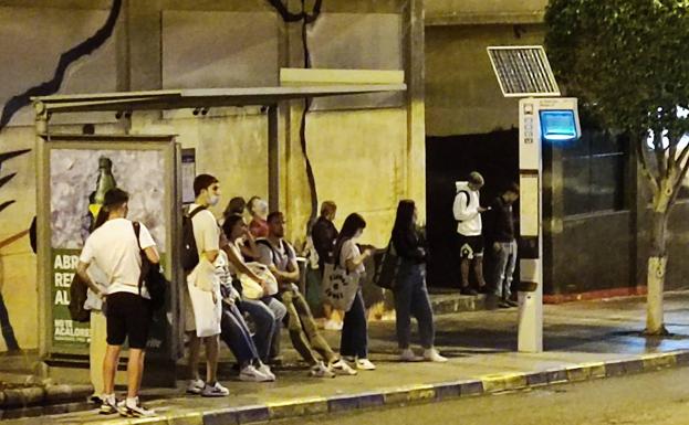 Usuarios de Guaguas esperan la llegada de la guagua en una parada. 