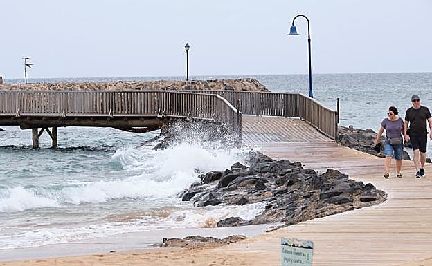 Turistas caminan por la pasarela de las playas artificiales de la Guirra, en el Castillo, en el municipio de Antigua. 