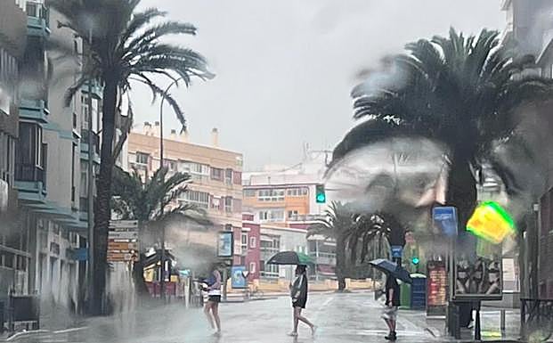 En la capital los paraguas apenas protegen de la tromba de agua. 