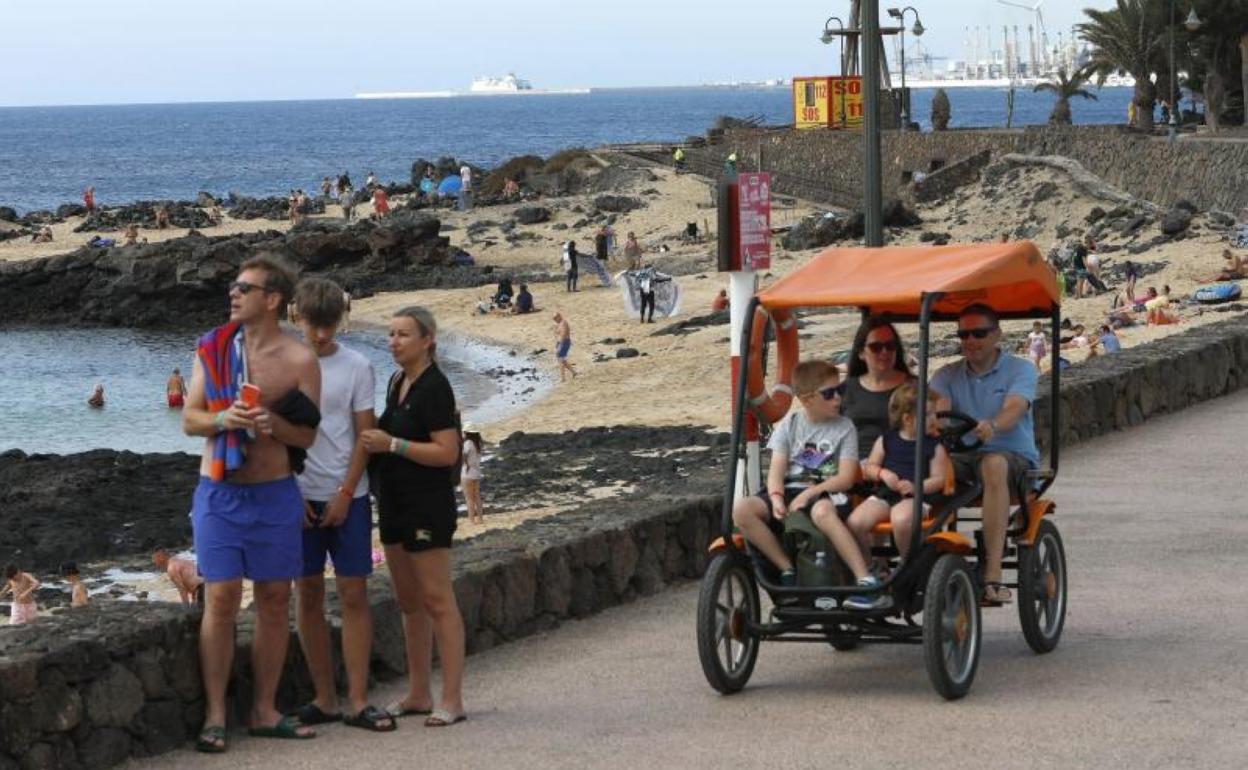 Un grupo de turistas pasean por el núcleo turístico de Costa Teguise, en Lanzarote. 