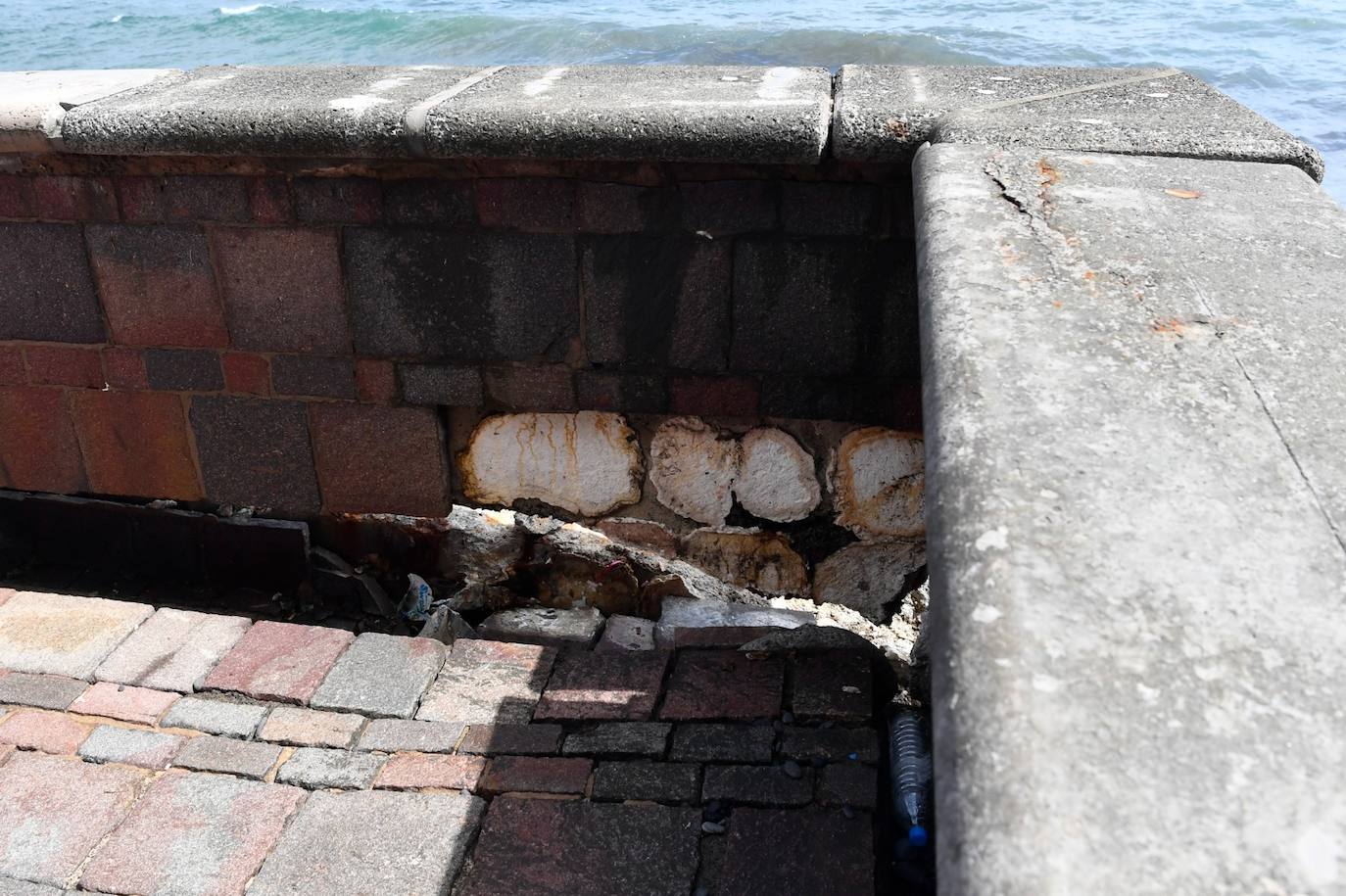Un muro del paseo ha cedido hacia el mar. 