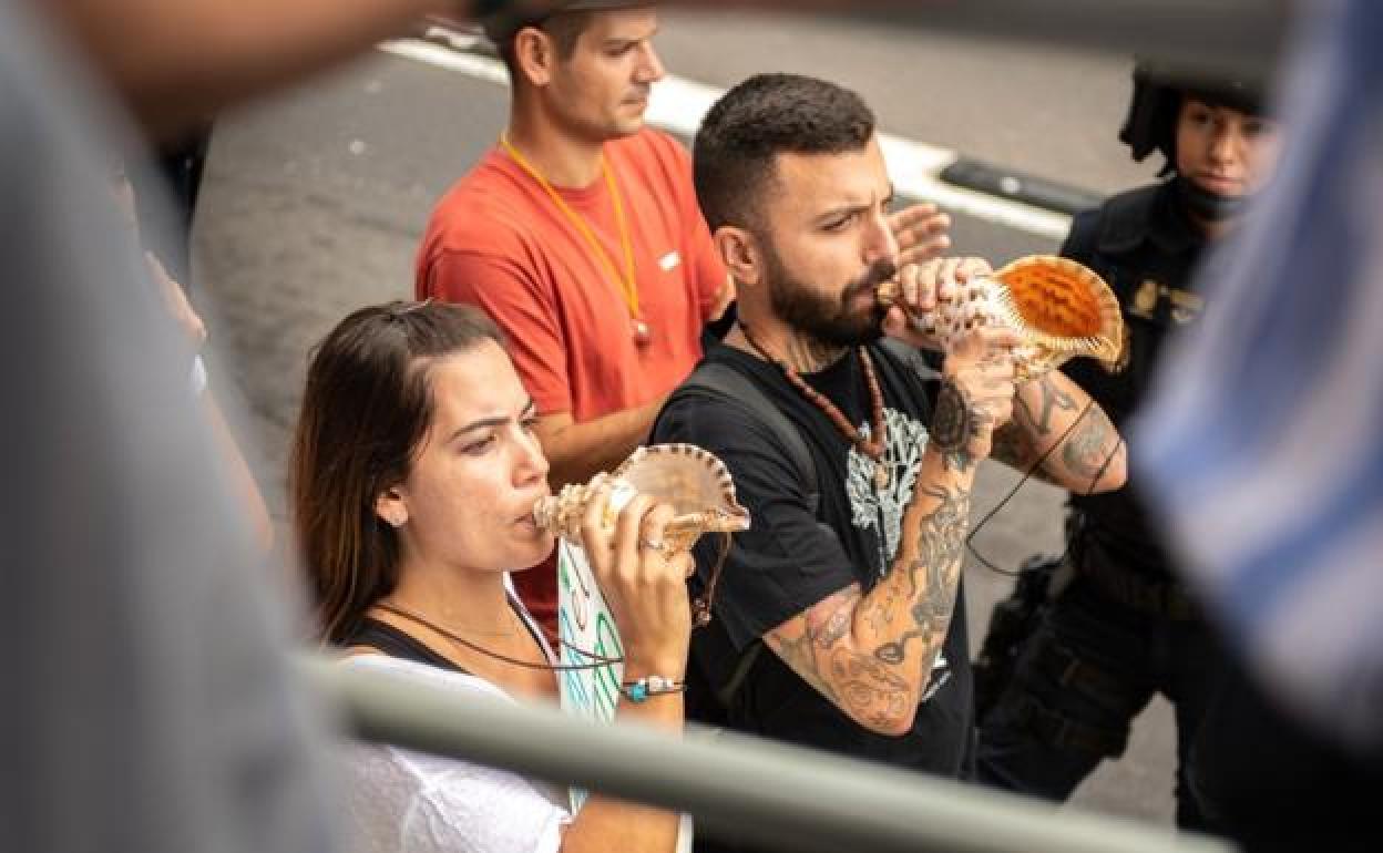 Dos personas haciendo sonar el bucio en Santa Cruz de Tenerife. 