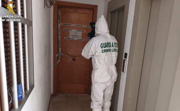 Un agente del laboratorio de criminalística de la Guardia Civil, junto a la casa donde se produjo el crimen. 