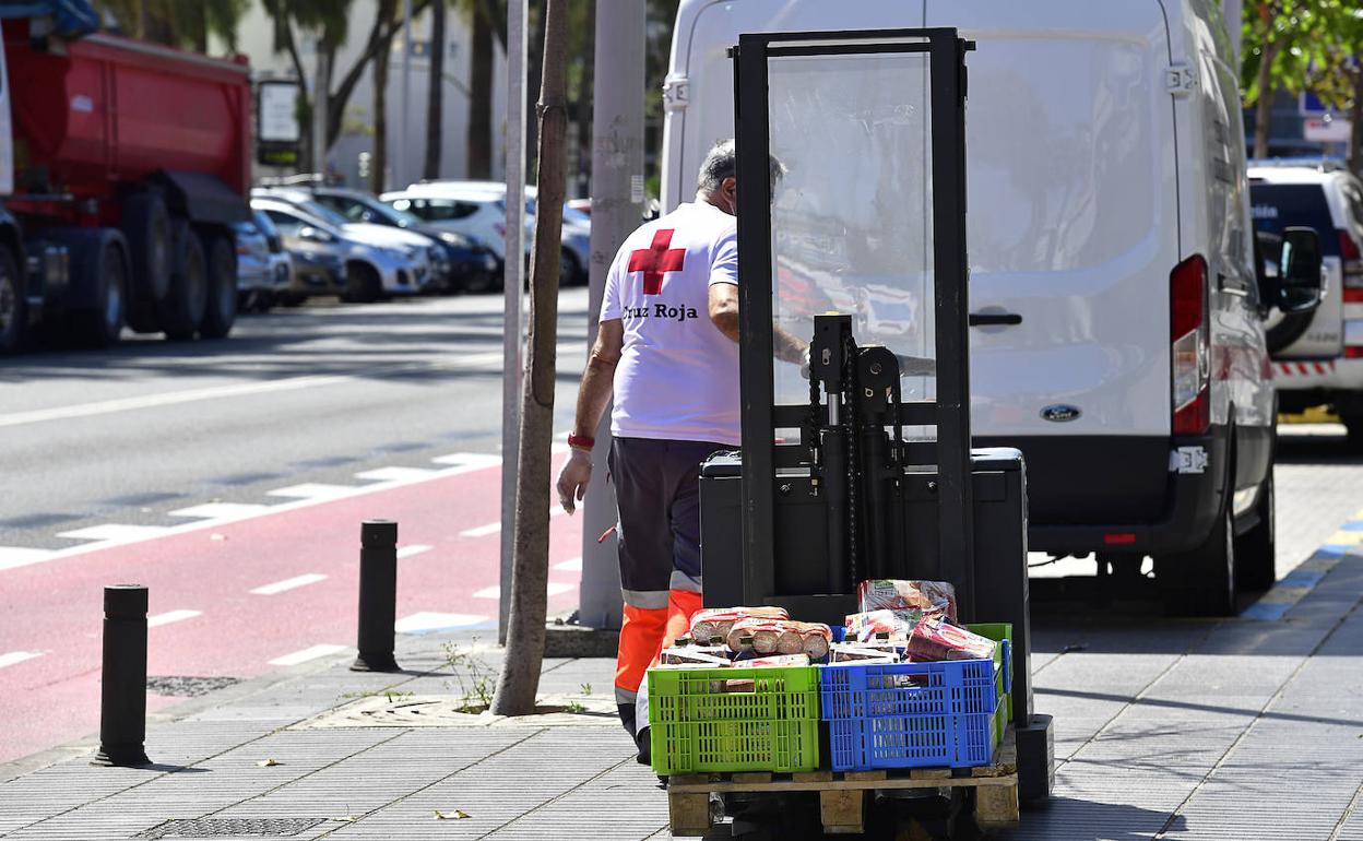 Un voluntario de Cruz Roja con alimentos para organizar ayudas en la capital grancanaria. 