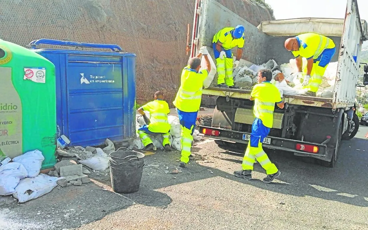 Trabajadores retiran escombros de una vía de la ciudad. 