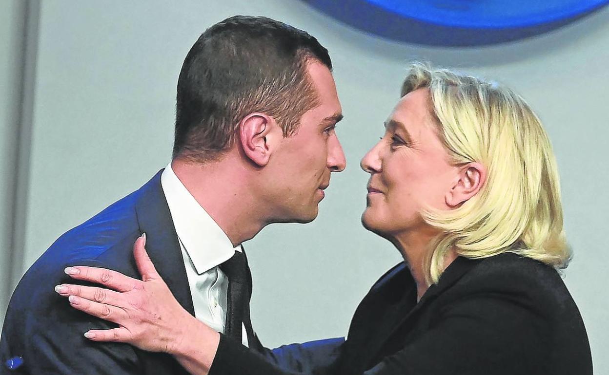 Marine Le Pen se dispone a besar a su sucesor, Jordan Bardella, durante el congreso.