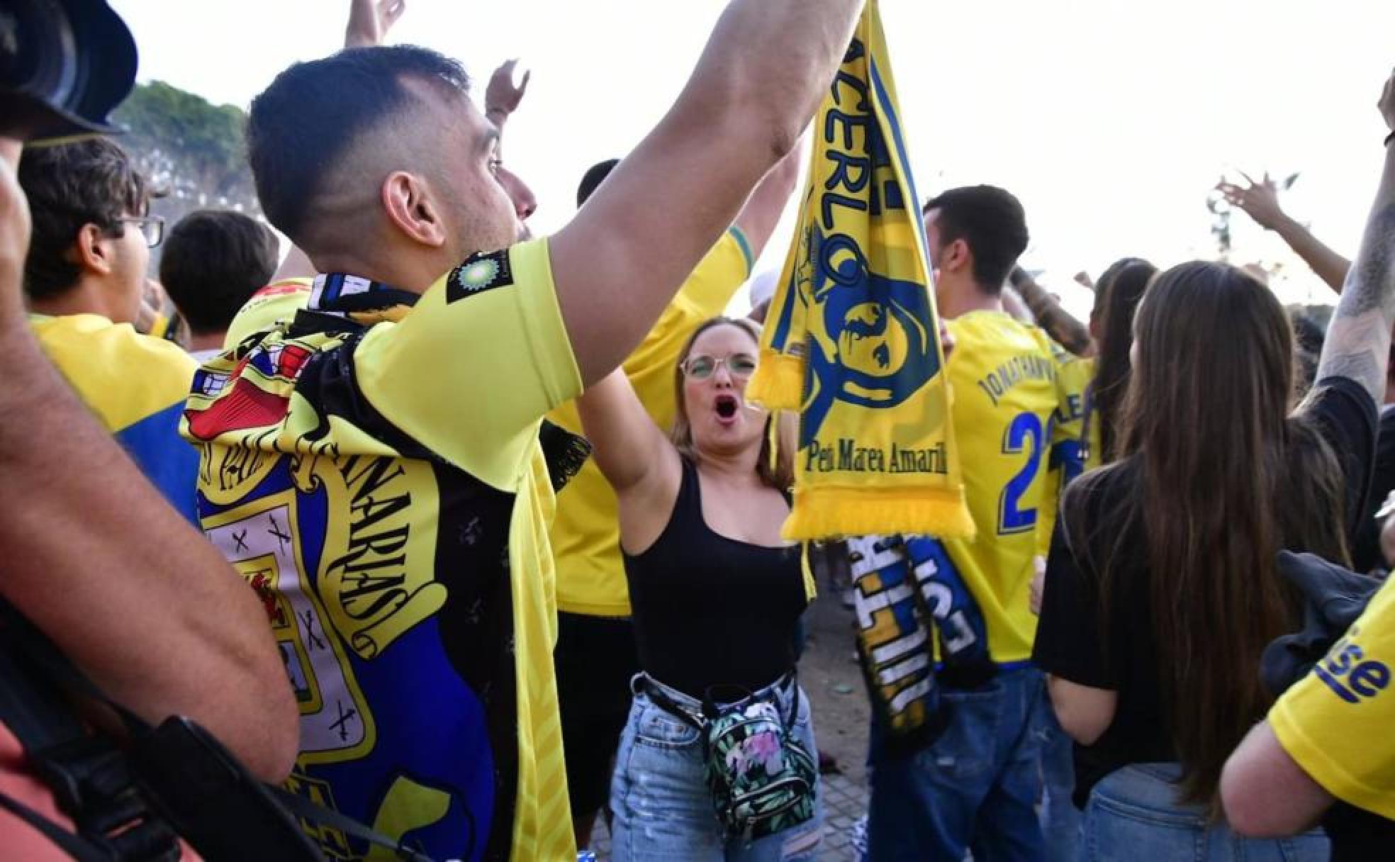Varios aficionados posan con los colores del equipo amarillo. 