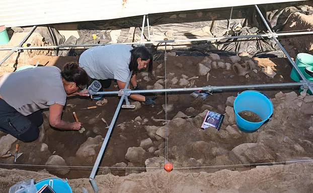Dos arqueólogas trabajan en la zona de 'basurero' o detritus de la nueva campaña arqueológica en el yacimiento Lobos I.