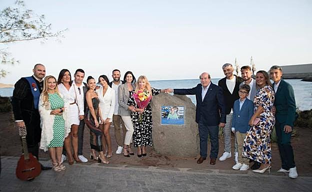 Imagen principal - En la foto superior, la familia posa con Juan Moreno junto al monolito colocado en el paseo marítimo. Debajo, foto antigua de Juan Moreno, sentado, y su padre Domingo, detrás de la barra, junto a dos clientes. Al lado, retrato de Josefa Martín Valerón, abuela de Juan y todo un referente en su vida. 