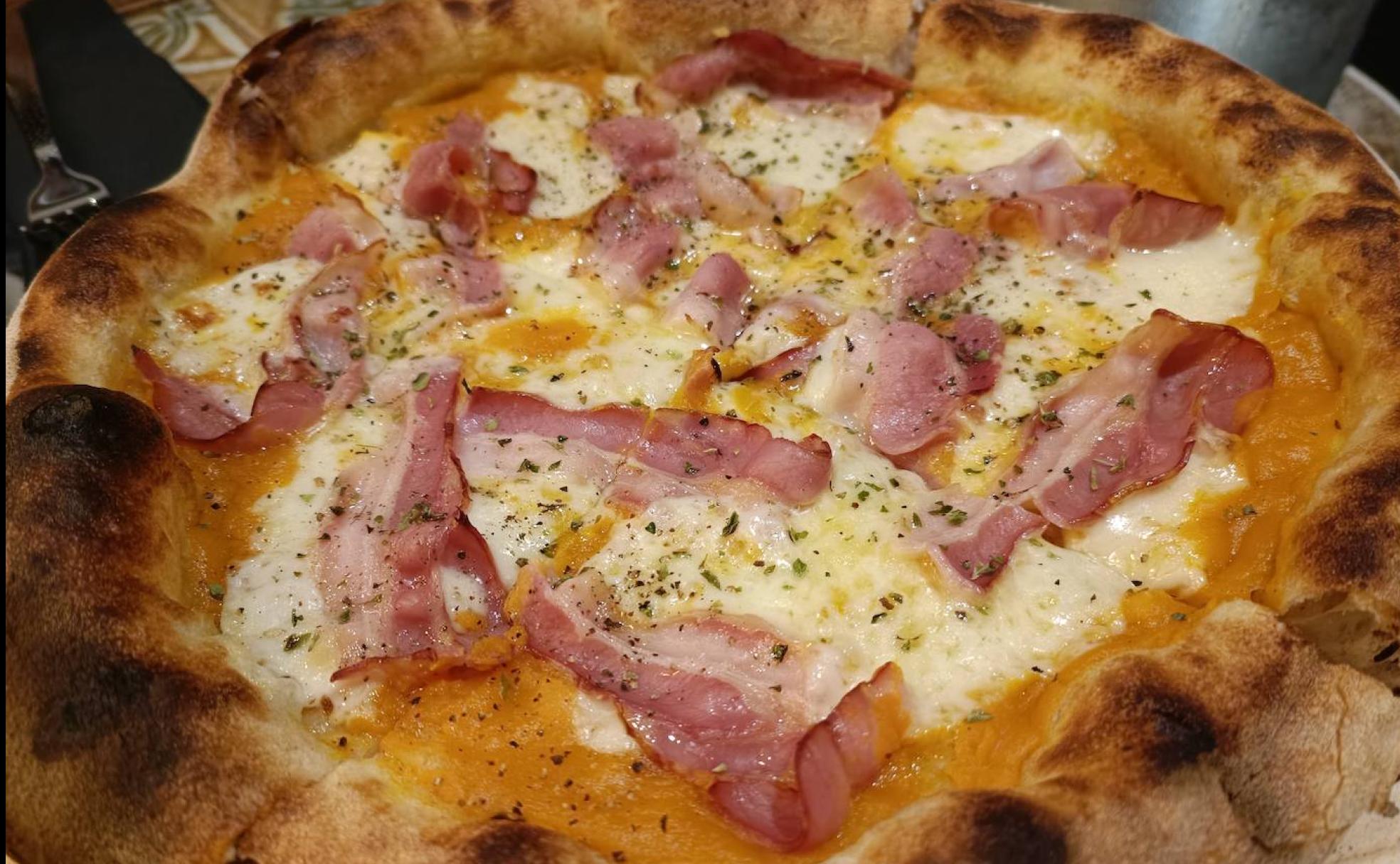 La pizza blanca con base de puré de calabaza, panceta ahumada y provolone. 