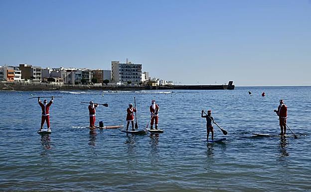 Papá Noel y sus ayudantes en la playa de Arinaga. 