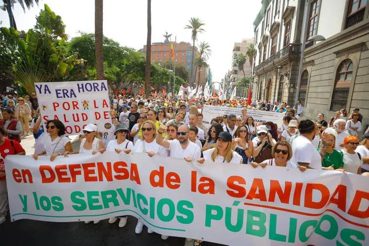 El presidente del comité de empresa del Instituto Canario de Hemodonacion y Hemoterapia de Tenerife, Daniel Quintero (2d), prepara una pancarta para la movilización.