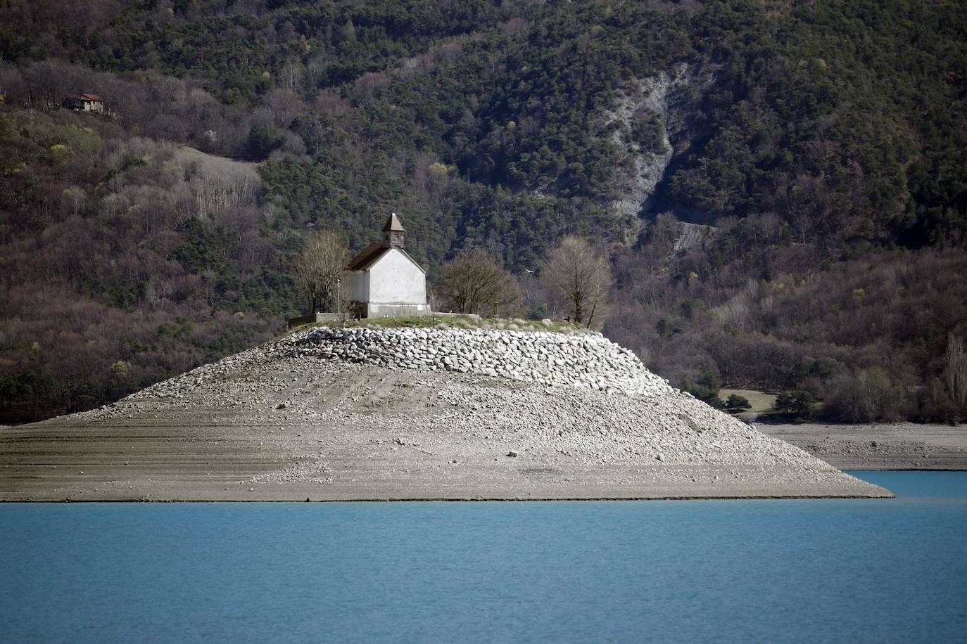 Vista de la antigua capilla en el lago de Serre-Poncon con bajo nivel de agua, ya que las aguas del lago descendieron bruscamente debido a la sequía que afecta a las regiones del sur de Francia, en Savines-le-Lac, Francia. El presidente francés, Macron, visitó Savines para anunciar un plan nacional de gestión del agua días después de una violenta manifestación de los opositores a una reserva de agua propuesta para el riego agrícola. 