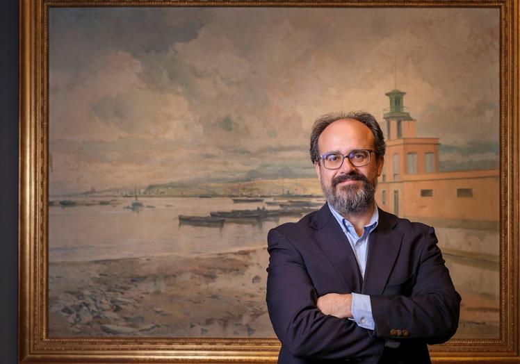 Francisco Javier Pueyo, comisario de 'Isla de Arte', posa frente a 'El puerto de refugio', de Eliseo Meifrén, pintor del siglo XIX.