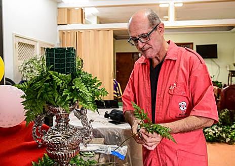 Imagen secundaria 1 - Arriba, el Cristo. Sobre estas líneas, Ramón con los arreglos florales y José Luis Rivero.