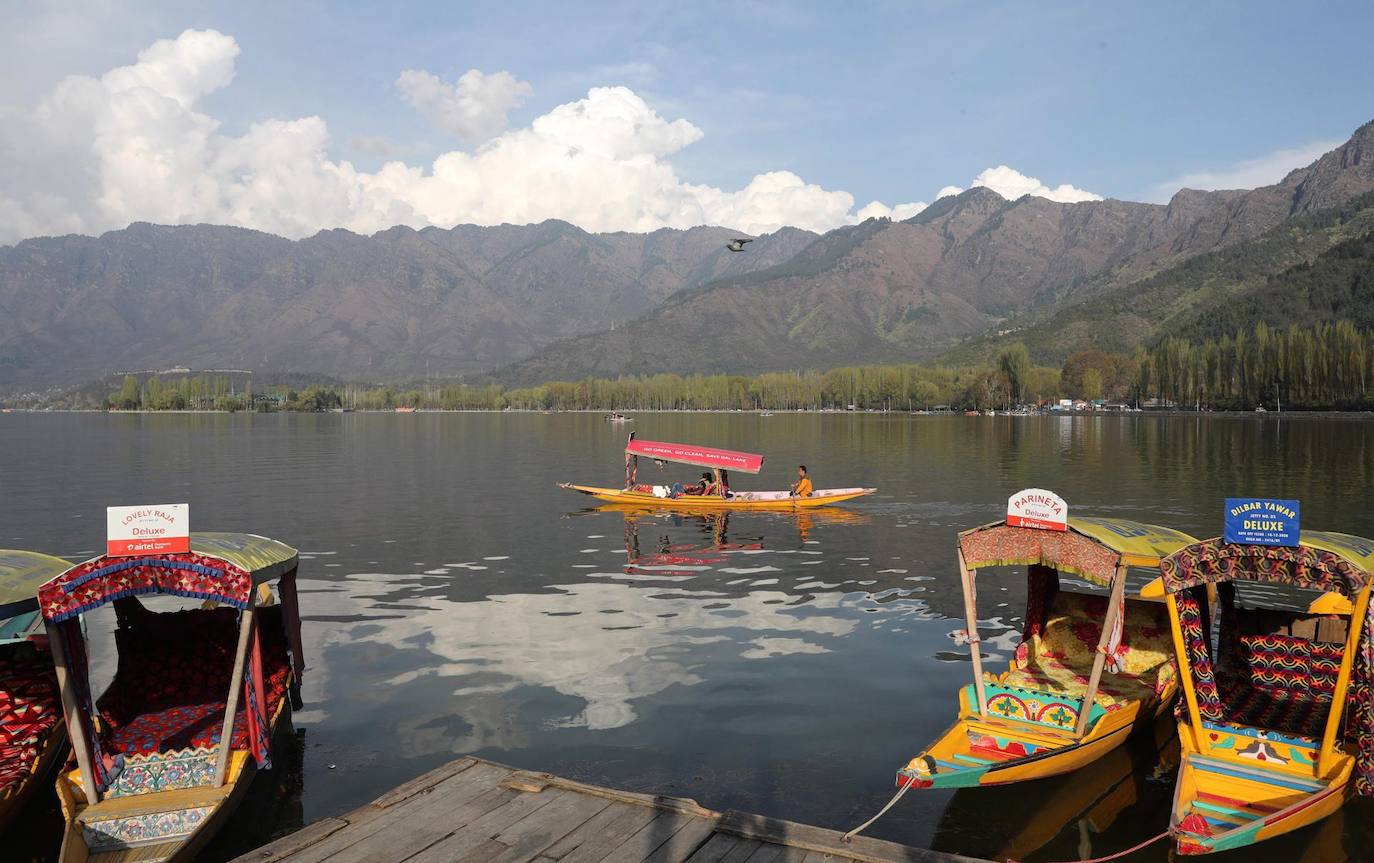 Los turistas disfrutan de un paseo en barco por las aguas del lago Dal en un día soleado en Srinagar, la capital de verano de la Cachemira india.