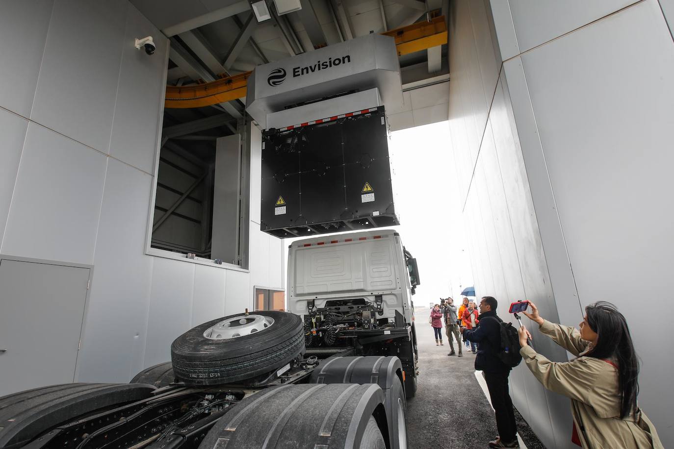 Los visitantes toman fotos de un camión de batería intercambiable en Envision Energy en el Parque Industrial Ordos Net-zero en la ciudad de Ordos, China. Nueve compañías de energía renovable, incluidas Envision, Longi y Huajing ha abierto sus sucursales en el Parque Industrial Ordos Net-zero, que está respaldado por energías renovables como la eólica y la solar. El parque industrial tiene como objetivo cero emisiones de carbono para su operación y las líneas de producción cubren energía eólica y solar, hidrógeno, almacenamiento de energía y vehículos eléctricos.