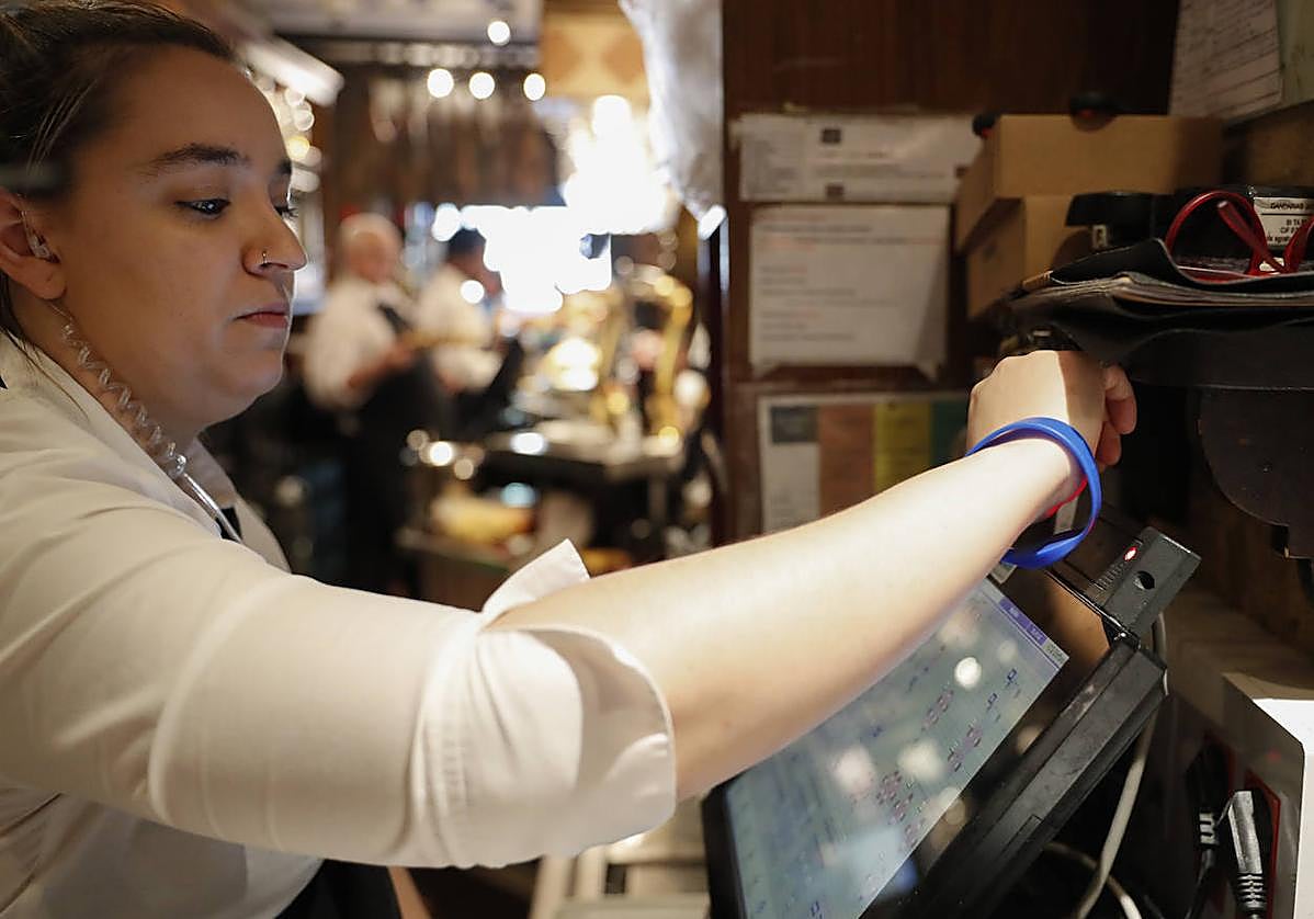 Una trabajadora ficha antes de comenzar su jornada laboral.
