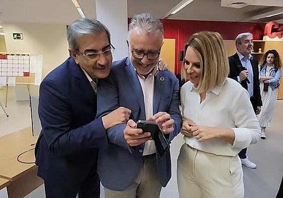Tres de los socios del Pacto de Las Flores observando una foto antigua