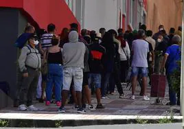 Imagen de personas haciendo cola ante Cáritas.