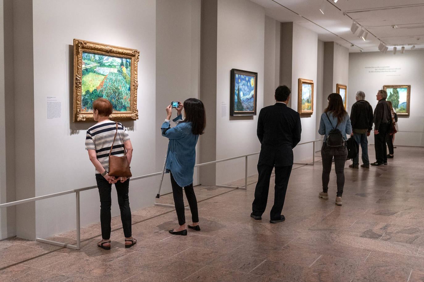 Personas observan algunas de las obras de Van Gogh, exhibidas durante la presentación de la muestra «Van Gogh's Cypresses», en la sede del Museo Metropolitano (Met), en Nueva York (EE. UU). El Met de Nueva York inauguró una exposición centrada en los cipreses del pintor holandés Vincent Van Gogh que revela que el maestro postimpresionista estuvo fascinado con estos árboles los dos últimos años de su vida, más tiempo del que se creía.