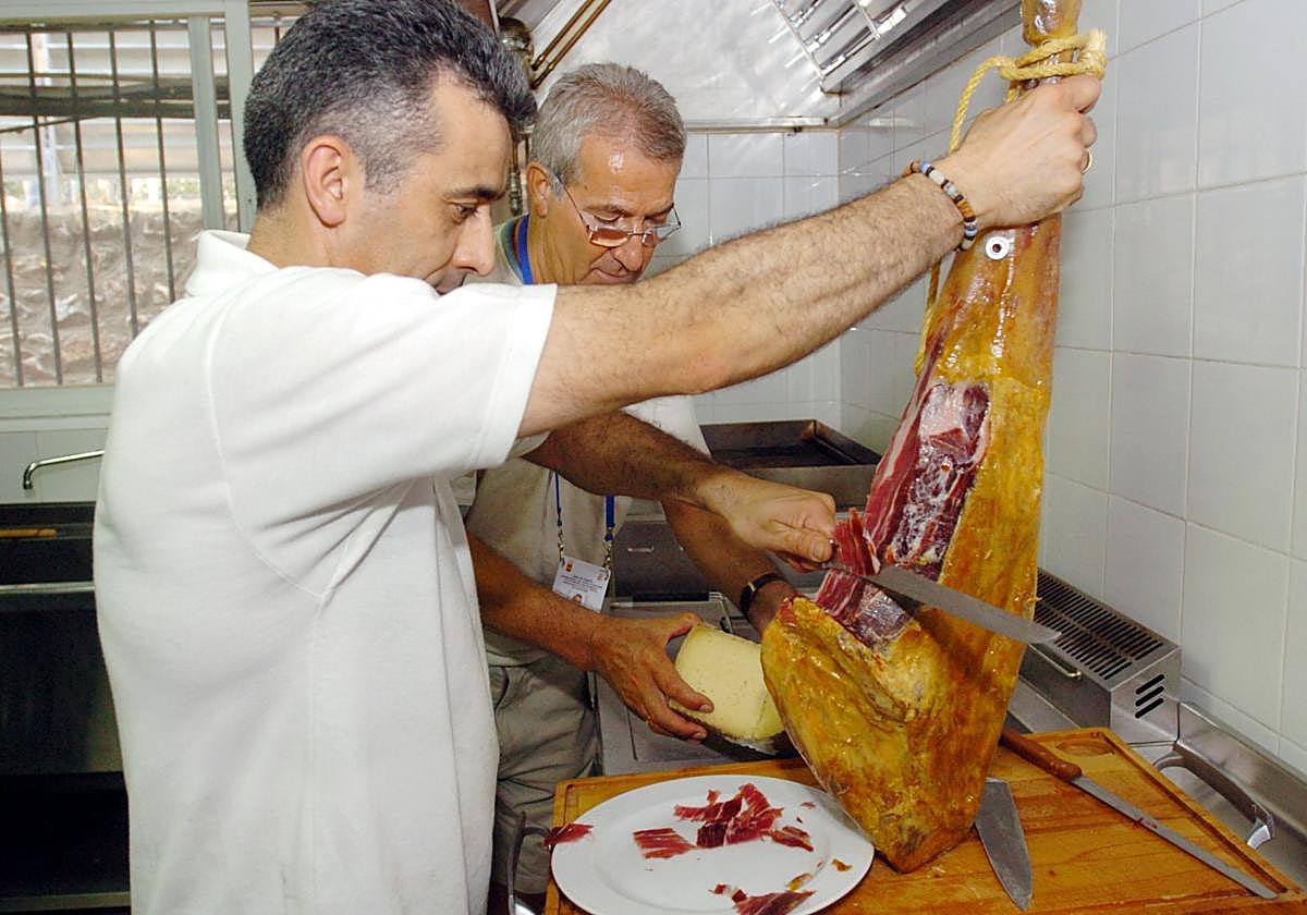 Imagen de archivo de una persona cortando un jamón ibérico.