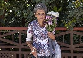Eugenio Espino, vecina de Tejeda con unas flores, a su salida del cementerio.
