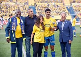 Coco sostiene el trofeo, con sus padres, Matías García y Nicolás Ortega, antes del partido.