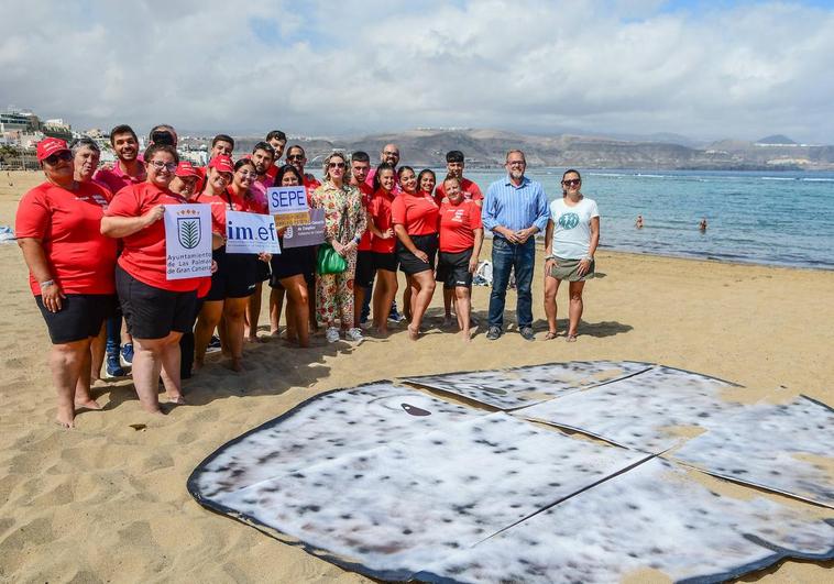 Imagen de los participantes en la celebración del Día Mundial de los Océanos en la playa de Las Canteras.