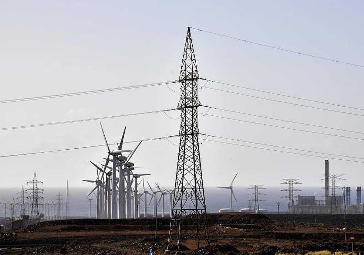 Torretas de alta tension y aeogeneradores en el entorno de la central térmica (derecha).