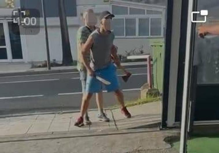 El autor de las amenazas con un hacha y un machete en cada mano.
