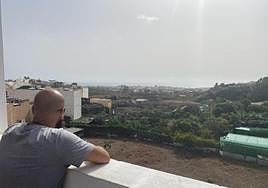 El vecino denunciante, en la azotea de su casa, mira a la finca donde están los gallos.