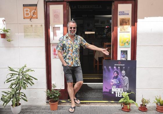 Luifer Rodríguez, en la puerta de entrada de la Tabernilla de Rosi, en la calle doctor Miguel Rosas, señala un cartel con sus dos roles en la serie.