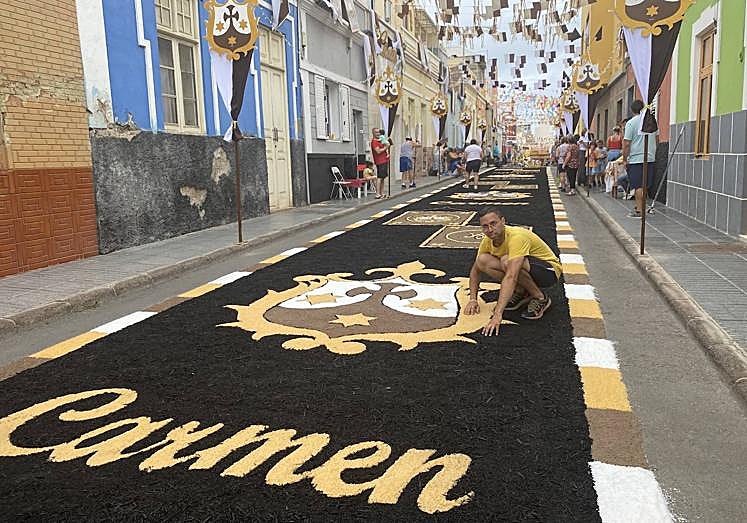 José Juan Díaz, en la alfombra de un tramo de la calle Menceyes. El diseño, obra de este joven. está inspirado en motivos carmelitas.