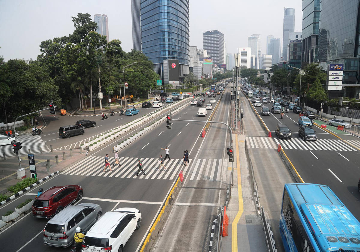 Peatones cruzan una calle principal en Yakarta, Indonesia, 26 de julio de 2023. Según Bank Indonesia (BI), la economía de Indonesia en el segundo trimestre de 2023 será mejor de lo estimado previamente en medio de altas incertidumbre mundial. El BI estima que el crecimiento económico de Indonesia en 2023 alcanzará el rango de 4,5-5,3 por ciento. Esto fue impulsado por el mayor consumo de los hogares y las inversiones.